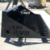 A black venom grill sitting on top of concrete.