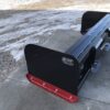 A black and red bench on the sidewalk