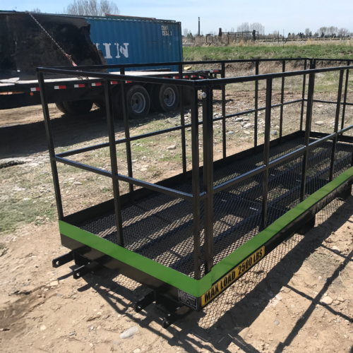 A green trailer with metal rails on it