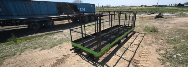 A green trailer with metal rails on it