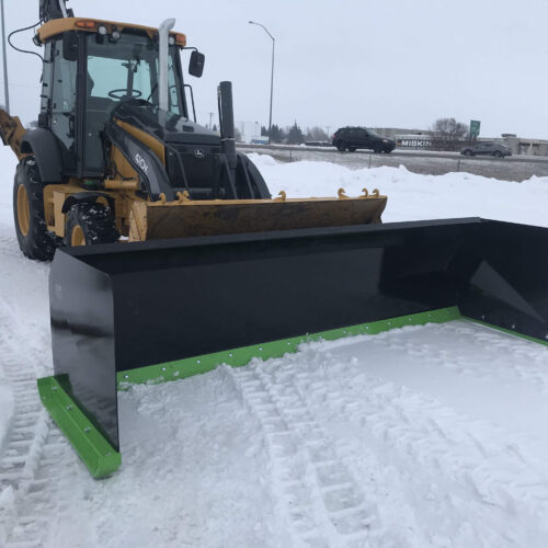 A tractor with a plow in the snow.