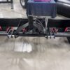 A black metal frame with multiple clamps attached in a workshop.