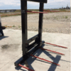 A black metal frame with red prongs on concrete outdoors.