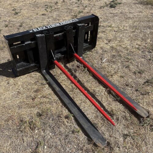 Heavy-duty hay bale spear attachment with three long tines.